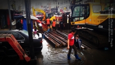 A woman walks on a flooded section of a street in Manila. Dirty water, such as this can cause diseases, including leptospirosis. Road projects that remain unfinished clogs the streets.