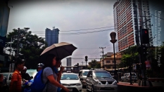 Umbrella. A group of people crosses the street in Manila. The heat in the city can be very scorching and although umbrellas can protect people from the sun's rays, the rising heat index is another issue.